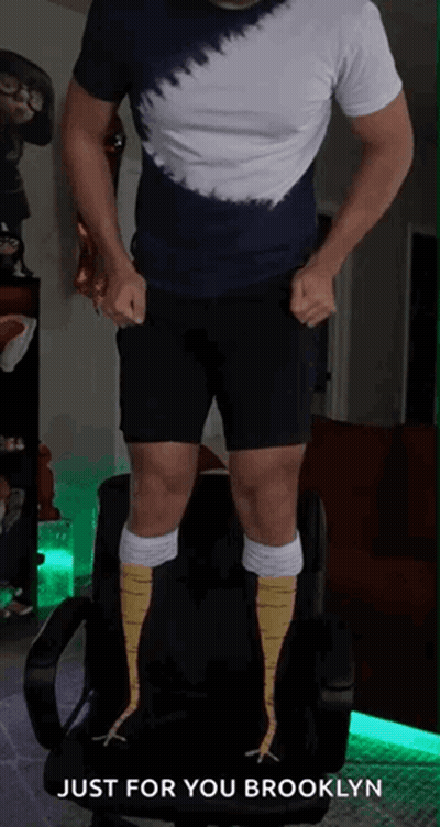 A Man In A Tie Dye Shirt And Black Shorts Is Standing On A Chair With The Words Just For You Brooklyn Above Him GIF