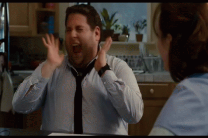 A Man In A Tie Is Laughing In A Kitchen GIF
