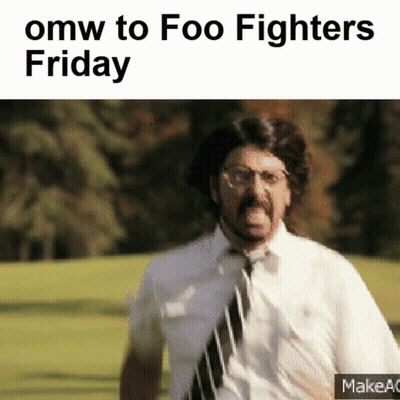 A Man In A Tie Is Running In A Field With The Words Omw To Foo Fighters Friday GIF