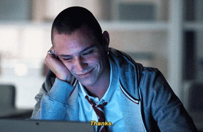 A Man In A Tie Is Smiling While Looking At A Computer Screen And The Words Thanks Are Visible GIF