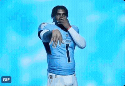 A Man In A Titans Jersey Is Standing In Front Of A Blue Light . GIF