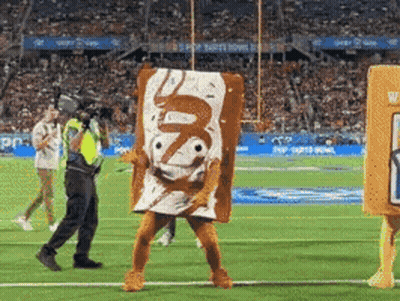 A Man In A Toaster Pastries Costume Is Walking On A Football Field GIF
