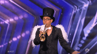 A Man In A Top Hat And Bow Tie Is Playing A Trumpet On A Stage Sponsored By Nbc GIF