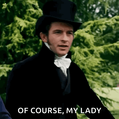 A Man In A Top Hat And Bow Tie Is Standing In Front Of Trees . GIF