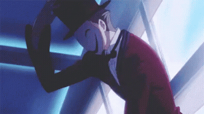 A Man In A Top Hat And Suit Is Standing In Front Of A Blue Wall . GIF