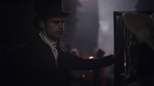 A Man In A Top Hat Is Looking At Something GIF