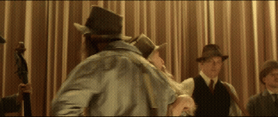 A Man In A Top Hat Stands In Front Of A Curtain GIF