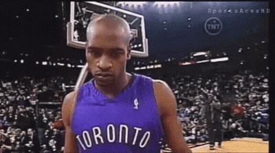 A Man In A Toronto Jersey Is Standing In Front Of A Crowd . GIF