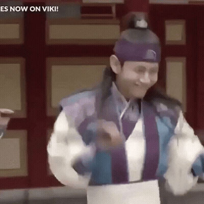 A Man In A Traditional Costume Is Dancing In Front Of A Wall . GIF