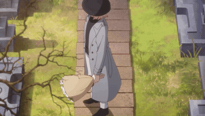 A Man In A Trench Coat And Hat Is Walking Down A Stone Path GIF