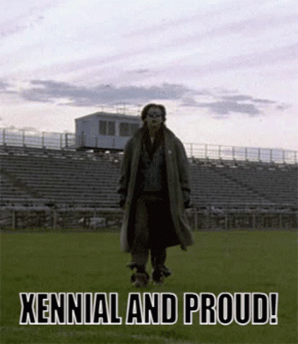 A Man In A Trench Coat Is Standing In A Field With The Words " Xennial And Proud " On The Bottom GIF