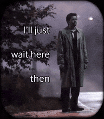 A Man In A Trench Coat Is Standing On A Sidewalk With The Words I 'Ll Just Wait Here Then GIF