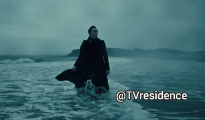 A Man In A Trench Coat Is Walking In The Ocean With The Words @Tvresidence Above Him GIF