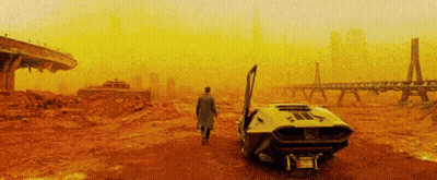 A Man In A Trench Coat Is Walking Towards A Car With Its Door Open In The Desert . GIF