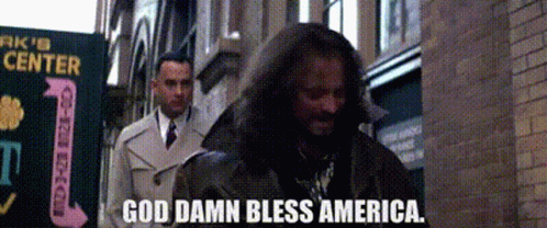 A Man In A Trench Coat Says God Damn Bless America . GIF