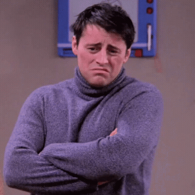 A Man In A Turtleneck Sweater Is Standing With His Arms Crossed . GIF