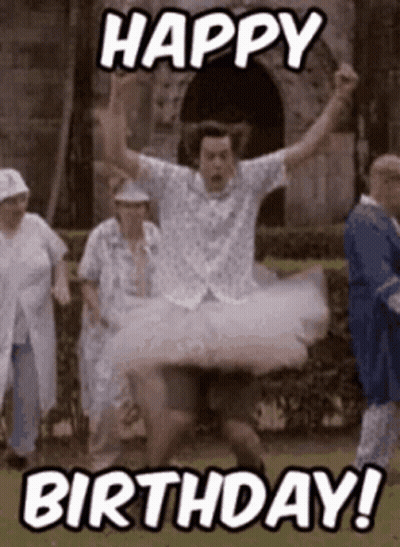 A Man In A Tutu Is Jumping In The Air While A Group Of People Are Standing Behind Him . GIF