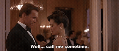 A Man In A Tuxedo And A Woman In A Black Dress Are Dancing In A Room . GIF