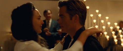 A Man In A Tuxedo And A Woman In A White Shirt Are Dancing GIF