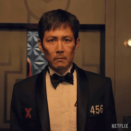 A Man In A Tuxedo And Bow Tie Has The Number 456 On His Shirt . GIF