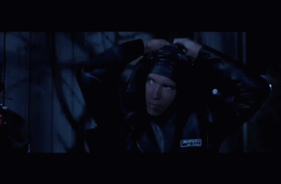 A Man In A Tuxedo And Bow Tie Is Looking Up In The Dark . GIF