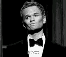 A Man In A Tuxedo And Bow Tie Is Making A Face . GIF