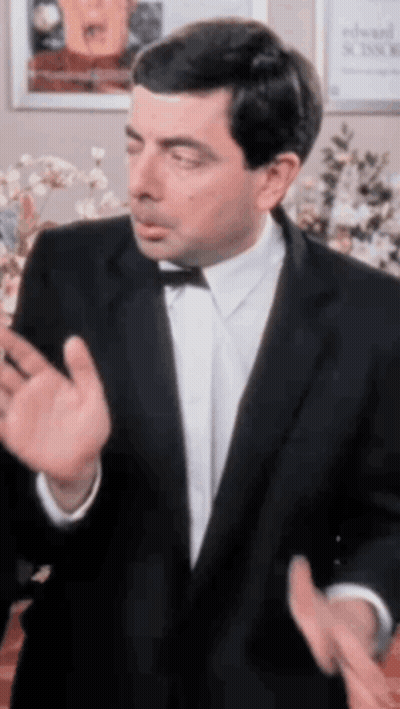 A Man In A Tuxedo And Bow Tie Is Making A Funny Face GIF
