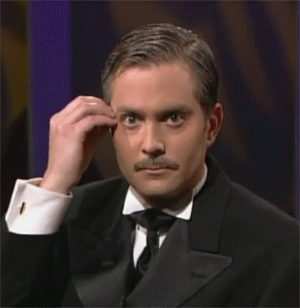 A Man In A Tuxedo And Bow Tie Is Making A Funny Face . GIF