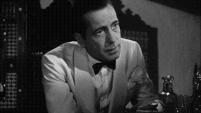 A Man In A Tuxedo And Bow Tie Looks At Something GIF