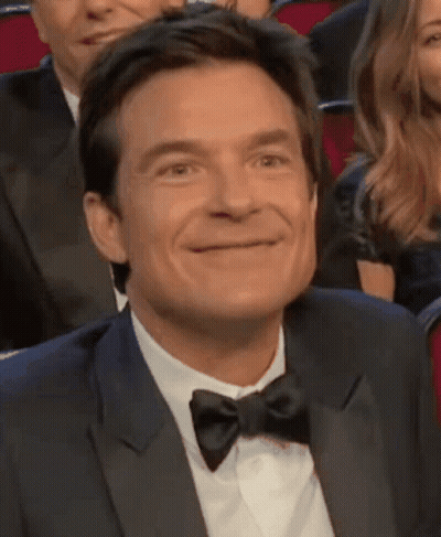 A Man In A Tuxedo And Bow Tie Smiles GIF
