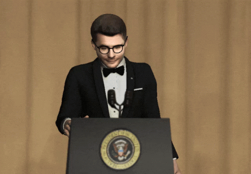 A Man In A Tuxedo And Bow Tie Stands At A Podium With The Seal Of The President Of The United States On It GIF