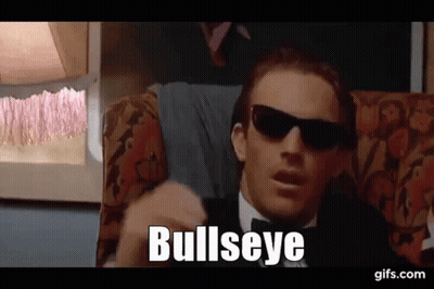 A Man In A Tuxedo And Sunglasses Is Sitting On A Couch And Saying `` Bullseye '' . GIF