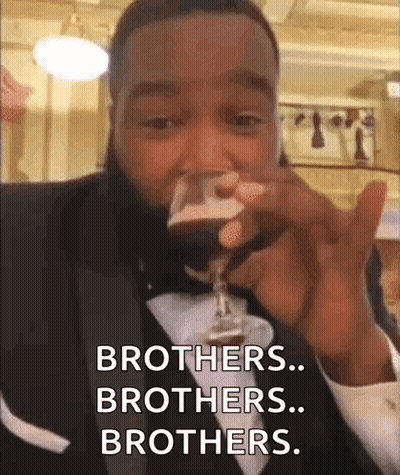 A Man In A Tuxedo Drinking From A Glass And Saying Brothers Brothers Brothers . GIF