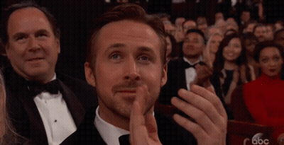 A Man In A Tuxedo Is Applauding While Sitting In A Crowd Of People . GIF