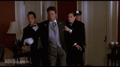 A Man In A Tuxedo Is Being Escorted By A Woman And A Man In A Police Uniform GIF