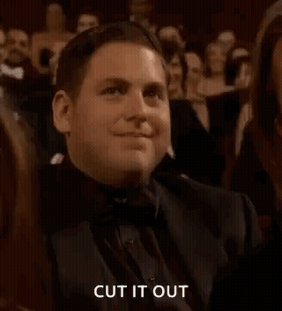 A Man In A Tuxedo Is Clapping In A Crowd At An Awards Show . GIF