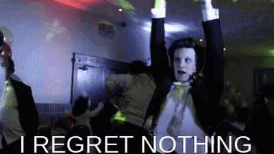 A Man In A Tuxedo Is Dancing With His Arms In The Air And The Words I Regret Nothing Below Him . GIF