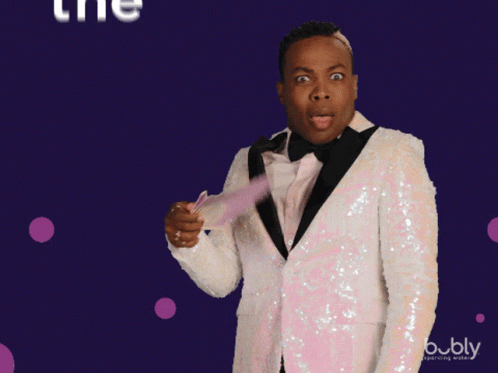A Man In A Tuxedo Is Holding A Fan And The Words The Shade Are Above Him GIF