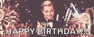 A Man In A Tuxedo Is Holding A Glass Of Champagne And Says Happy Birthday !!! GIF
