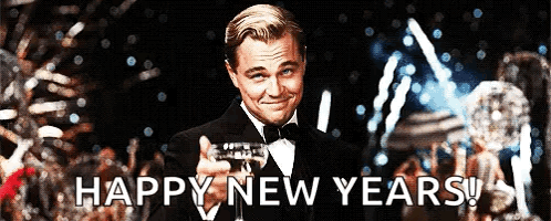 A Man In A Tuxedo Is Holding A Glass Of Champagne With The Words Happy New Years Behind Him GIF