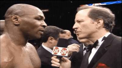 A Man In A Tuxedo Is Holding A Microphone That Says Shosho GIF