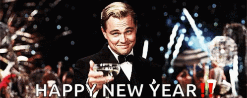 A Man In A Tuxedo Is Pointing At The Camera With The Words Happy New Year Written Below Him GIF