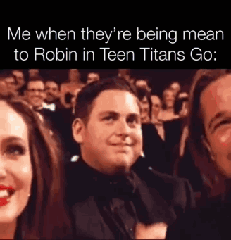 A Man In A Tuxedo Is Sitting In Front Of A Crowd . GIF