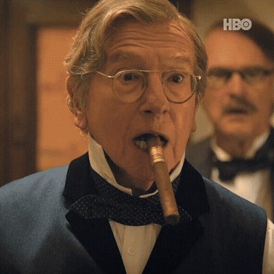 A Man In A Tuxedo Is Smoking A Cigar With The Hbo Logo In The Corner GIF