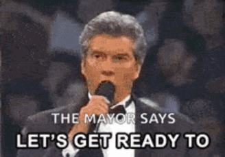 A Man In A Tuxedo Is Speaking Into A Microphone And Says Let 'S Get Ready To GIF