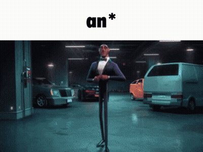 A Man In A Tuxedo Is Standing In A Parking Garage With Cars And The Word An * Above Him GIF