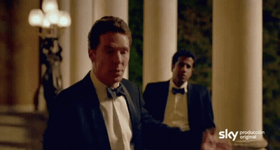 A Man In A Tuxedo Is Standing In Front Of A Sign That Says Sky Production GIF