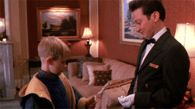A Man In A Tuxedo Is Standing Next To A Boy In A Living Room GIF