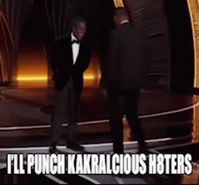A Man In A Tuxedo Is Standing Next To Another Man With The Words " I 'Ll Punch Kakralicious Hoters " GIF