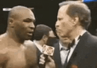 A Man In A Tuxedo Is Talking To A Boxer . GIF